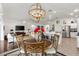 Open floor plan with dining room chandelier and views of living room and modern kitchen at 3566 Gentle Ter, The Villages, FL 32163