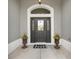 Inviting entryway featuring decorative door, transom window, and potted plants for a warm welcome at 3566 Gentle Ter, The Villages, FL 32163