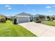 Charming single-story home with a two-car garage, manicured landscaping, and a well-maintained lawn at 3566 Gentle Ter, The Villages, FL 32163