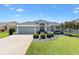 Beautiful home exterior featuring manicured landscaping, neutral paint and elegant architectural details during the day at 3566 Gentle Ter, The Villages, FL 32163