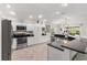 Kitchen featuring stainless appliances, black countertops, white cabinets, and a view of the dining area at 3566 Gentle Ter, The Villages, FL 32163