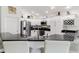 Modern kitchen with white cabinets, black countertops, stainless steel appliances, and a wine rack at 3566 Gentle Ter, The Villages, FL 32163