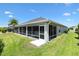 Back view of screened-in lanai offering ample seating and space to enjoy the backyard's serene atmosphere at 3566 Gentle Ter, The Villages, FL 32163