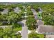 Aerial view of a home with mature trees and a community street and a green map marker at 3586 Eversholt St, Clermont, FL 34711