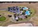 Aerial view of a community pool, clubhouse, golf course, and expansive parking lot, all surrounded by lush greenery at 3586 Eversholt St, Clermont, FL 34711