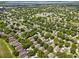 Aerial view of a community featuring residential homes and green landscape, all with a golf course nearby at 3586 Eversholt St, Clermont, FL 34711