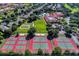 Aerial view of tennis and basketball courts, manicured lawns, a resort-style pool, and clubhouse in a sunny community at 3586 Eversholt St, Clermont, FL 34711