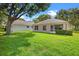 Well-maintained backyard with lush green grass and mature trees surrounding the property at 3586 Eversholt St, Clermont, FL 34711