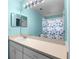 Bathroom with a large mirror, single vanity, and butterfly-patterned shower curtain at 3586 Eversholt St, Clermont, FL 34711