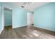 Bedroom featuring light-blue walls, wood-look floors, ceiling fan, and doors at 3586 Eversholt St, Clermont, FL 34711