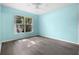 Bedroom featuring light-blue walls, wood-look floors, ceiling fan, and window at 3586 Eversholt St, Clermont, FL 34711