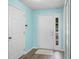 Entryway featuring gray floors, light-blue walls, and a white door with sidelight window at 3586 Eversholt St, Clermont, FL 34711