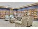 Inviting library space with cozy seating, carpeted floors, and extensive bookshelves filled with a variety of reading materials at 3586 Eversholt St, Clermont, FL 34711