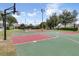 Outdoor recreation area featuring a basketball court and tennis court surrounded by lush greenery at 3586 Eversholt St, Clermont, FL 34711