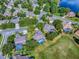 Aerial view of the neighborhood and the home, featuring a screened pool and landscaping at 359 Blue Branch St, Eustis, FL 32736