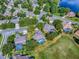 Aerial view of the neighborhood and the home, featuring a screened pool and landscaping, inside property lines at 359 Blue Branch St, Eustis, FL 32736