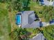 Aerial view of the home featuring a screened pool, beautiful landscaping, and a driveway, inside property lines at 359 Blue Branch St, Eustis, FL 32736