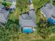 Aerial view of the home featuring a screened pool, beautiful landscaping, and a driveway, inside property lines at 359 Blue Branch St, Eustis, FL 32736