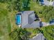 Aerial view of the home featuring a screened pool, beautiful landscaping, and a driveway at 359 Blue Branch St, Eustis, FL 32736