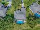 Aerial view of the home featuring a screened pool, beautiful landscaping, and a driveway at 359 Blue Branch St, Eustis, FL 32736