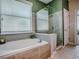 Modern bathroom featuring a separate shower, soaking tub, and tiled walls at 359 Blue Branch St, Eustis, FL 32736