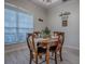 Cozy dining area features a round wooden table and matching chairs, flooded with natural light from a large window at 359 Blue Branch St, Eustis, FL 32736