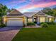 Charming single-story home featuring a well-manicured lawn, brick driveway, and an attached two-car garage at 359 Blue Branch St, Eustis, FL 32736