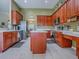 Spacious kitchen with wood cabinetry, a center island, stainless steel appliances, and tiled flooring at 359 Blue Branch St, Eustis, FL 32736