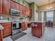 Efficient kitchen boasts wood cabinetry, stainless steel appliances, and a center island for meal preparation at 359 Blue Branch St, Eustis, FL 32736