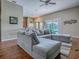Bright living room with hardwood floors, open to the kitchen and dining area, featuring a large sectional sofa at 359 Blue Branch St, Eustis, FL 32736