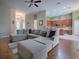 Open-concept living room with hardwood floors, a large sectional sofa, and a view of the kitchen at 359 Blue Branch St, Eustis, FL 32736