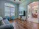 Bright sitting room featuring wood-look floors, a large window, and an open concept to dining room at 359 Blue Branch St, Eustis, FL 32736
