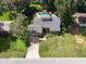 Bird's eye view of a home with a gray roof, a pool with waterfall, mature trees, and lush green lawns at 3664 Se 45Th Pl, Ocala, FL 34480