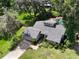 An aerial view shows a single-Gathering home, pool with waterfall, two car garage and surrounding greenery at 3664 Se 45Th Pl, Ocala, FL 34480