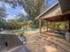 Beautiful home with pool, outdoor kitchen, covered dining area, and lush landscaping at 3664 Se 45Th Pl, Ocala, FL 34480