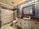 Nicely appointed bathroom with tiled walk-in shower, cherry wood vanity, and decorative accents at 3664 Se 45Th Pl, Ocala, FL 34480