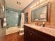 Full bathroom with a tile-surround shower/tub combination and a vanity with dark wood cabinets and granite countertops at 3664 Se 45Th Pl, Ocala, FL 34480