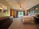 Spacious carpeted bedroom featuring sliding glass doors to the backyard, a ceiling fan, and neutral decor at 3664 Se 45Th Pl, Ocala, FL 34480