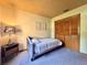 Cozy bedroom featuring soft carpet, closet, and a decorative lamp on side table at 3664 Se 45Th Pl, Ocala, FL 34480