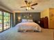 View of a carpeted bedroom featuring sliding glass doors to the backyard, a ceiling fan, and neutral decor at 3664 Se 45Th Pl, Ocala, FL 34480