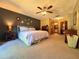 Open and spacious bedroom with ensuite bath, plush carpet, a ceiling fan, and neutral décor at 3664 Se 45Th Pl, Ocala, FL 34480