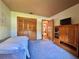 Bedroom with plush carpet, closet, TV cabinet, and an open doorway at 3664 Se 45Th Pl, Ocala, FL 34480