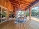Covered patio with a wooden ceiling and deck, an outdoor dining set, and string lights with a pool view at 3664 Se 45Th Pl, Ocala, FL 34480