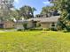 Charming home featuring stone accents, a well-kept lawn, and a two-car garage nestled under lush trees at 3664 Se 45Th Pl, Ocala, FL 34480