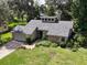 Aerial view of a home with stone accents, a well-manicured lawn, and a two-car garage in a lush green neighborhood at 3664 Se 45Th Pl, Ocala, FL 34480