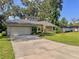Charming single-Gathering home features an attached two-car garage, stone accents, and a long concrete driveway at 3664 Se 45Th Pl, Ocala, FL 34480