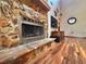 Close up of beautiful stone fireplace, hardwood floors, and adjacent display cabinet at 3664 Se 45Th Pl, Ocala, FL 34480