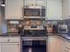 Updated kitchen with stainless steel appliances, mosaic backsplash, and black countertops at 3664 Se 45Th Pl, Ocala, FL 34480