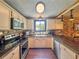 Well-lit kitchen with stainless steel appliances, white cabinetry and black countertops at 3664 Se 45Th Pl, Ocala, FL 34480