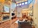 Spacious living room with a stone fireplace, hardwood floors, vaulted ceilings, and natural light at 3664 Se 45Th Pl, Ocala, FL 34480